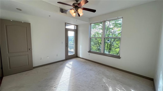 carpeted spare room featuring ceiling fan and a healthy amount of sunlight