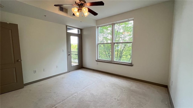 carpeted spare room with a wealth of natural light and ceiling fan