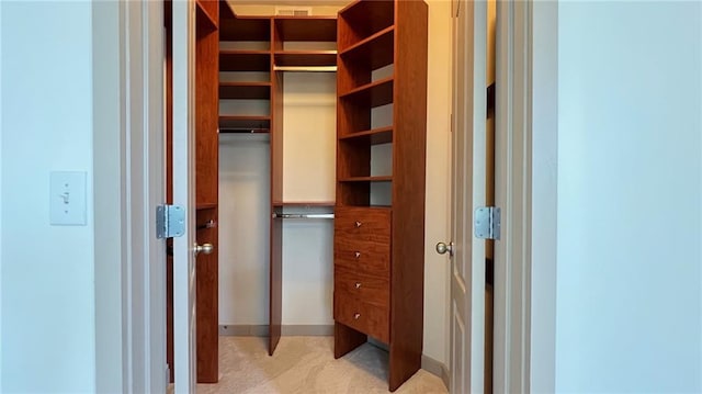 walk in closet featuring light carpet