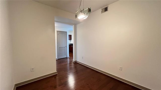 empty room with dark hardwood / wood-style flooring