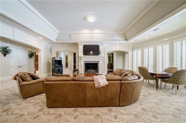 living room with crown molding, a fireplace, and a tray ceiling