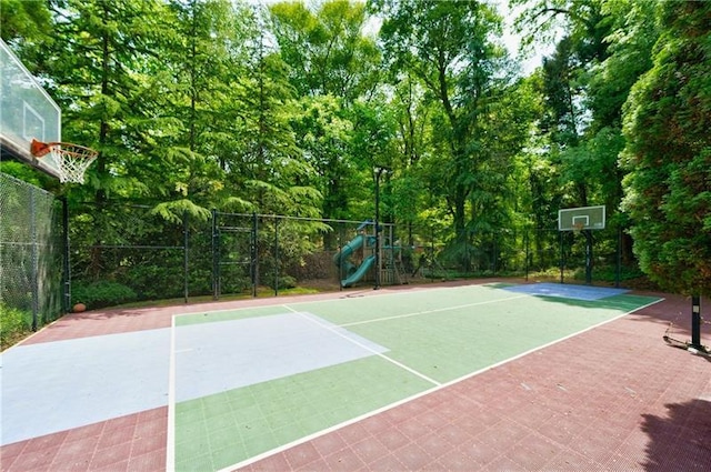 view of basketball court with a playground