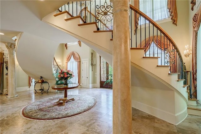 foyer entrance featuring decorative columns and a high ceiling