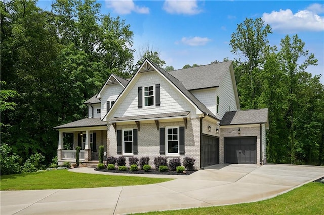 view of front of property with a porch, a garage, a front yard, concrete driveway, and brick siding