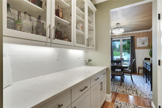 4383 Capstone Ct NE, Roswell, GA 30075 - bar with ornamental molding, a chandelier, and light wood finished floors