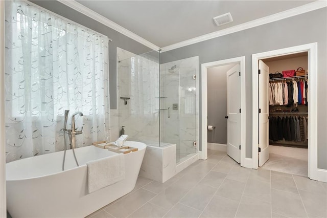 full bathroom with a stall shower, ornamental molding, a freestanding tub, a walk in closet, and baseboards