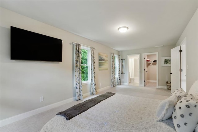 carpeted bedroom with baseboards, a spacious closet, connected bathroom, and a closet