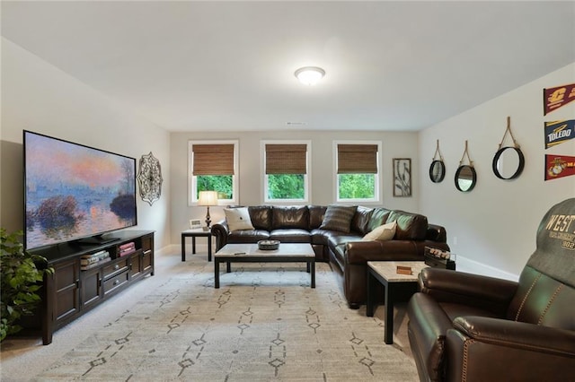 living room with baseboards and light carpet