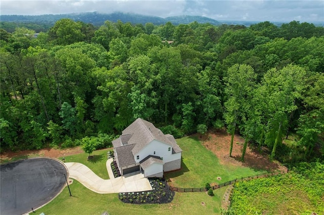 aerial view of property and surrounding area with a heavily wooded area