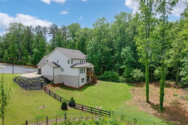 rear view of property with a deck and a view of trees