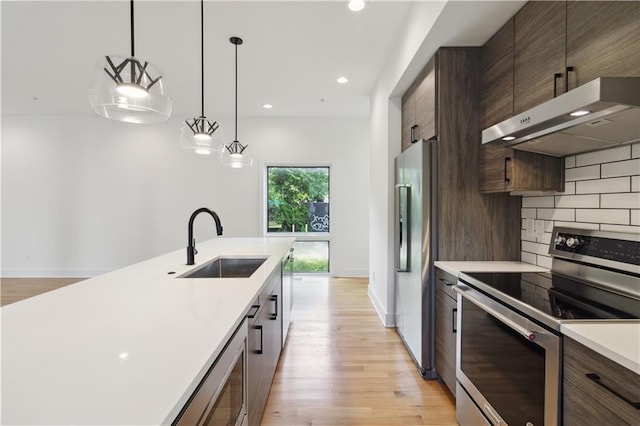 367 Parkway Dr NE Unit 9, Atlanta, GA 30312 - kitchen featuring stainless steel appliances, under cabinet range hood, a sink, light countertops, and light wood-type flooring