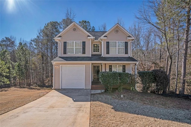 traditional home with a garage, concrete driveway, and a porch