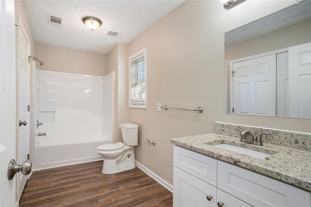 full bath featuring a textured ceiling, toilet, wood finished floors, vanity, and visible vents