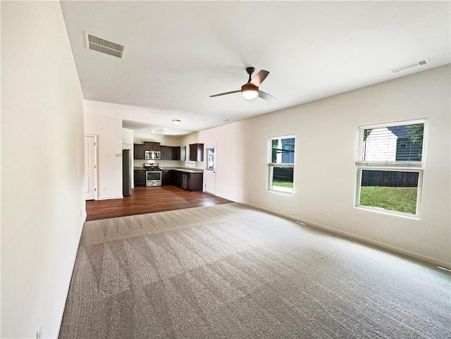 unfurnished living room featuring ceiling fan and carpet floors