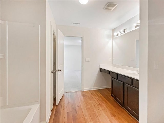 bathroom featuring vanity, wood-type flooring, and a washtub