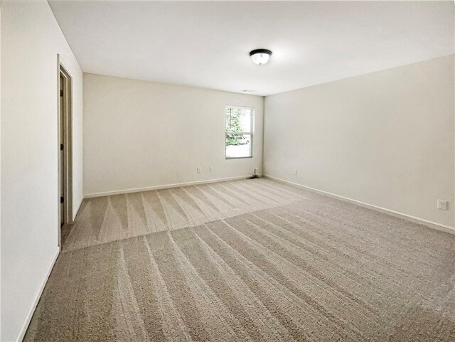 unfurnished room featuring light carpet