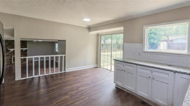 1328 Hoy Taylor Dr, Norcross, GA 30093 - kitchen with dark wood finished floors, backsplash, light stone counters, baseboards, and white cabinets