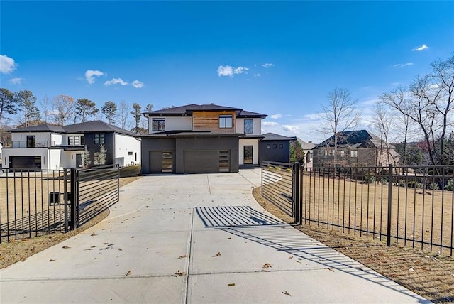 view of front of house featuring stucco siding, a gate, fence, concrete driveway, and a garage