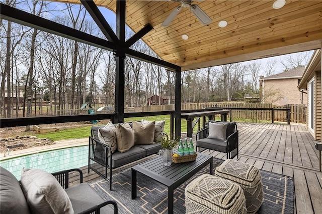 wooden deck with an outdoor living space, a ceiling fan, and a fenced backyard