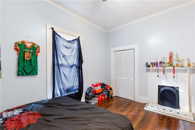 bedroom with a closet, dark hardwood / wood-style floors, and crown molding