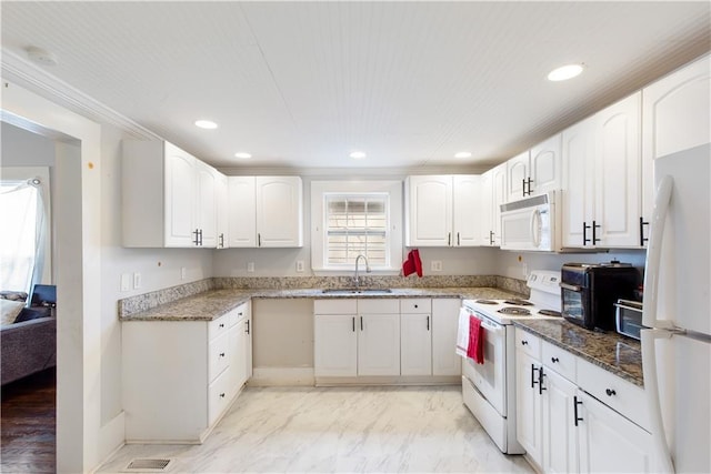 kitchen with white cabinetry, sink, dark stone countertops, and white appliances