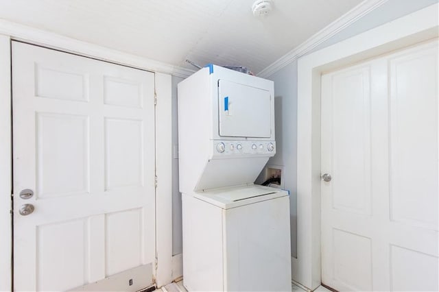 washroom featuring ornamental molding and stacked washer and clothes dryer