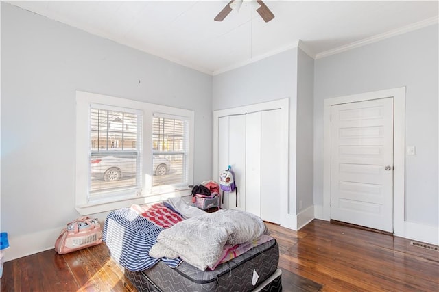 bedroom with ceiling fan, ornamental molding, and dark hardwood / wood-style floors