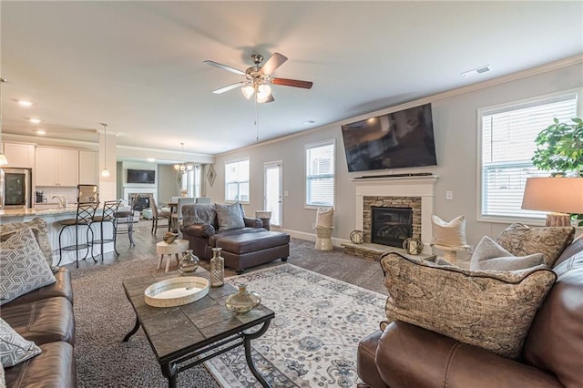 living room featuring ceiling fan, crown molding, a fireplace, and hardwood / wood-style flooring