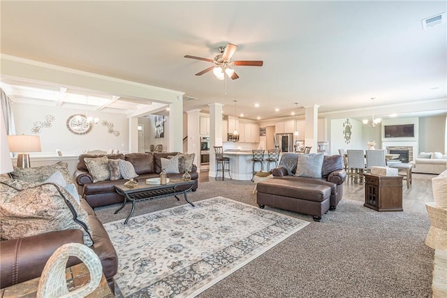 living room with beam ceiling, ceiling fan with notable chandelier, decorative columns, and ornamental molding