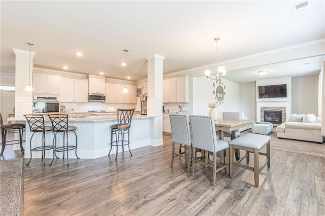 dining area with a chandelier, light hardwood / wood-style floors, and a fireplace