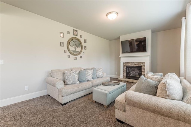 carpeted living room with a stone fireplace