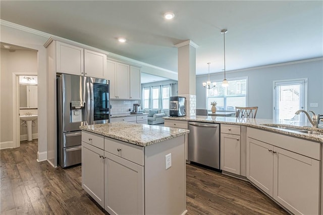 kitchen featuring dark hardwood / wood-style floors, stainless steel appliances, a center island, backsplash, and hanging light fixtures