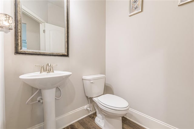 bathroom with toilet and wood-type flooring