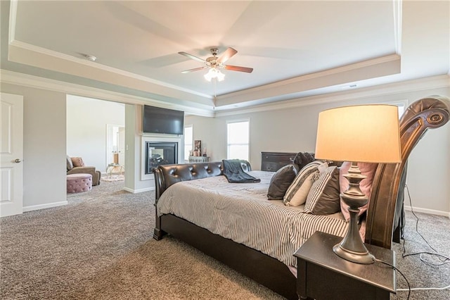 bedroom featuring ceiling fan, crown molding, a raised ceiling, and carpet floors