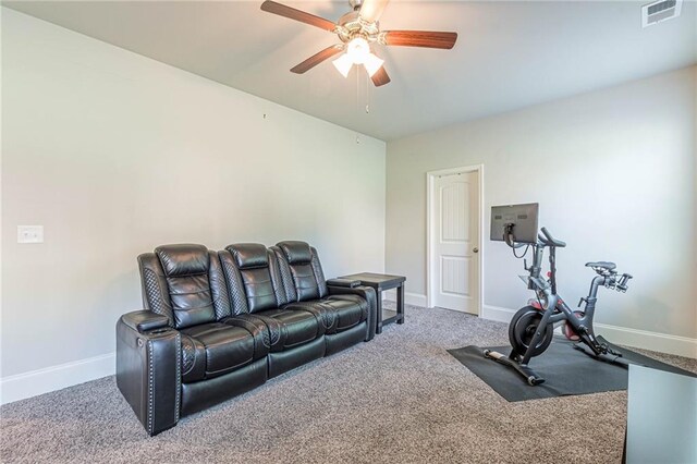 exercise room featuring ceiling fan and dark colored carpet