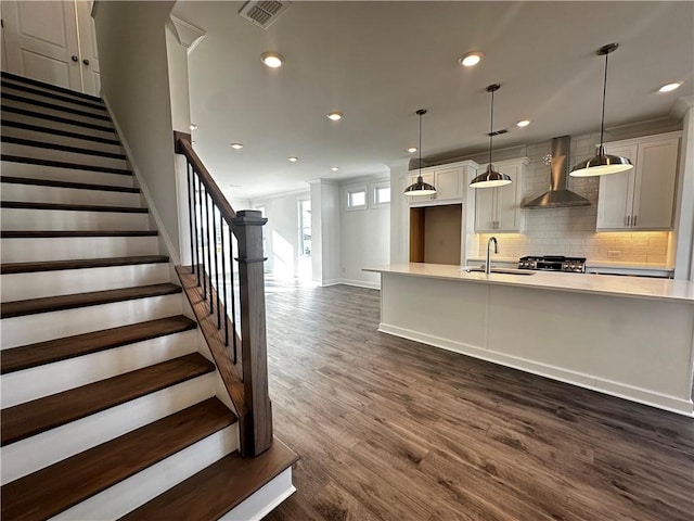 508 Healy Dr Unit 70, Cumming, GA 30040 - kitchen with wall chimney exhaust hood, a sink, light countertops, tasteful backsplash, and recessed lighting