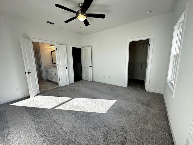 508 Healy Dr Unit 70, Cumming, GA 30040 - unfurnished bedroom featuring carpet flooring, baseboards, a walk in closet, ensuite bath, and a ceiling fan
