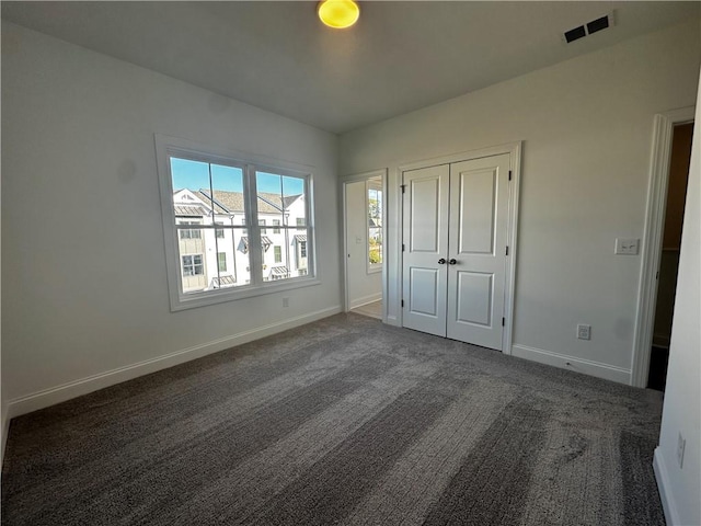 508 Healy Dr Unit 70, Cumming, GA 30040 - unfurnished bedroom featuring carpet floors, baseboards, and a closet
