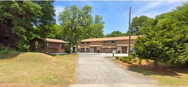 view of front of property featuring aphalt driveway and a front yard