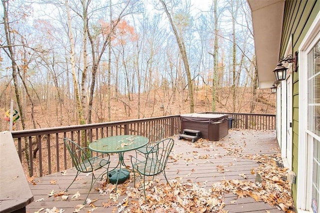 deck featuring outdoor dining space and a hot tub