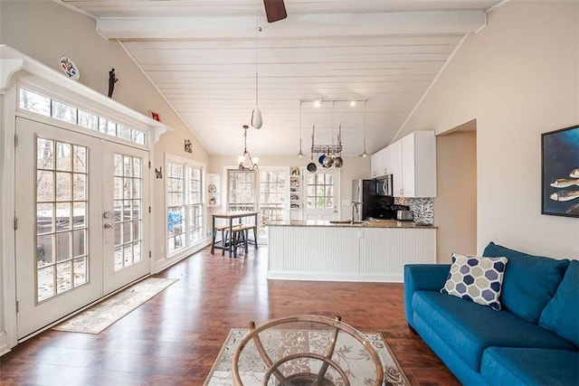 living area with track lighting, french doors, lofted ceiling with beams, and dark wood-style flooring