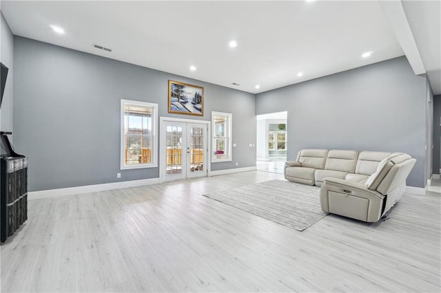 living area with french doors, baseboards, light wood-style floors, and visible vents