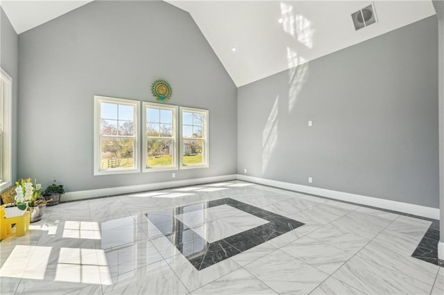 spare room featuring visible vents, marble finish floor, high vaulted ceiling, and baseboards