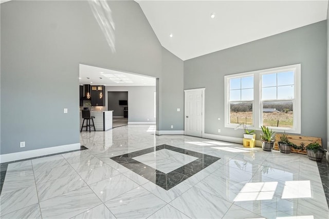 unfurnished room with recessed lighting, marble finish floor, high vaulted ceiling, and baseboards