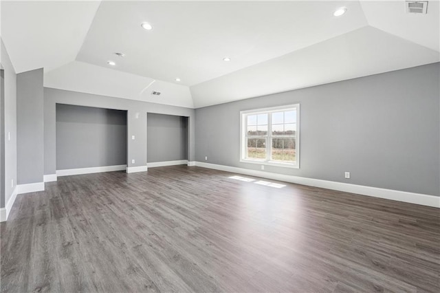 unfurnished bedroom featuring vaulted ceiling, wood finished floors, baseboards, and visible vents