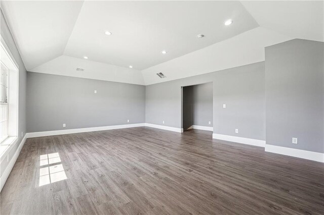 empty room with visible vents, baseboards, lofted ceiling, recessed lighting, and wood finished floors