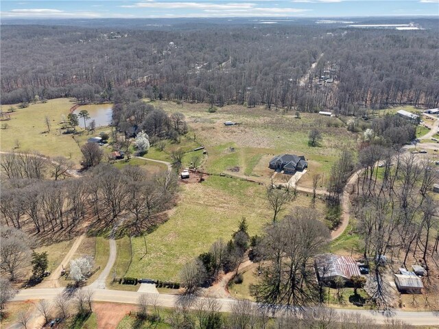 birds eye view of property with a rural view and a wooded view