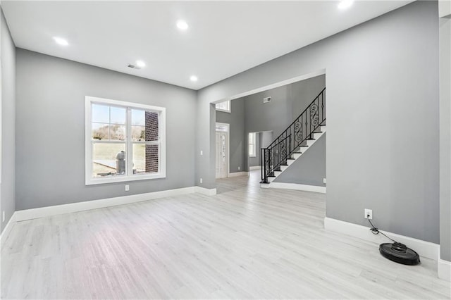 interior space featuring visible vents, baseboards, stairway, recessed lighting, and wood finished floors