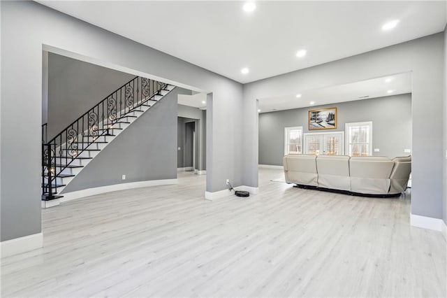 living room with stairs, wood finished floors, and baseboards