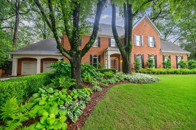 663 Clifton Rd NE, Atlanta, GA 30307 - colonial house with brick siding, an attached garage, a front lawn, and a shingled roof
